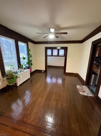 a view of an empty room with wooden floor and a floor to ceiling window