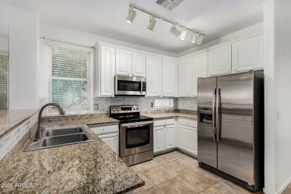 a kitchen with a refrigerator sink and stainless steel appliances