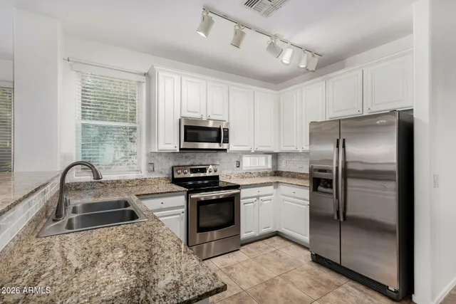 a kitchen with a refrigerator sink and stainless steel appliances