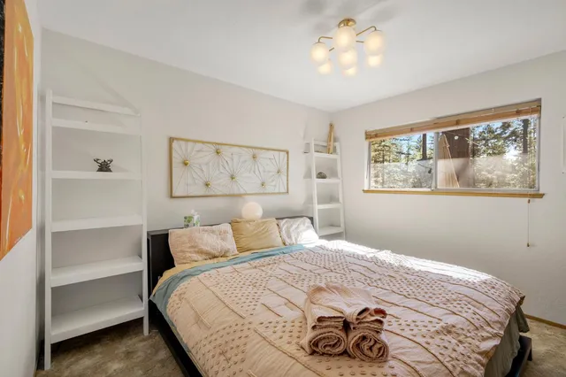 a bedroom with a bed and a painting on the wall