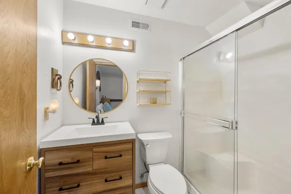 a bathroom with a sink a toilet and shower