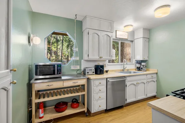 a kitchen with stainless steel appliances a stove a sink and a microwave