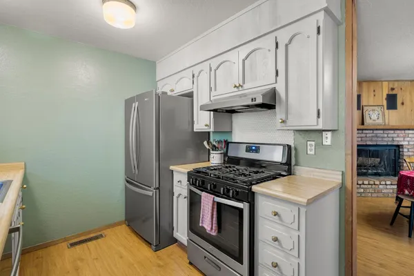 a kitchen with stainless steel appliances granite countertop a stove a refrigerator and a sink