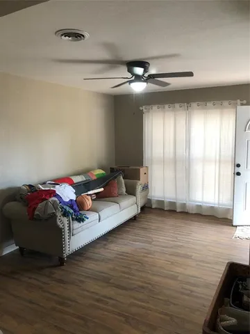 a living room with furniture and a ceiling fan