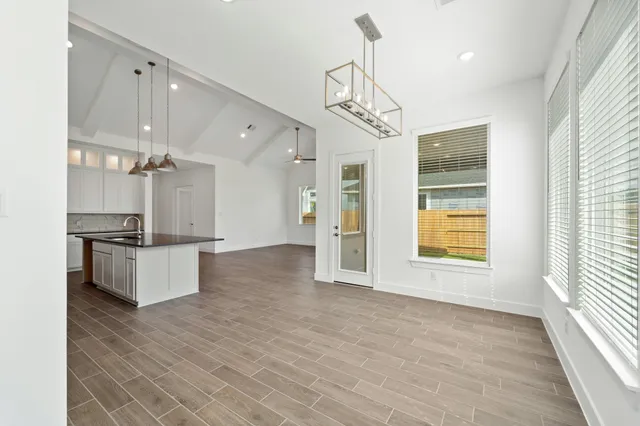 a large kitchen with granite countertop a large counter top space appliances and cabinets