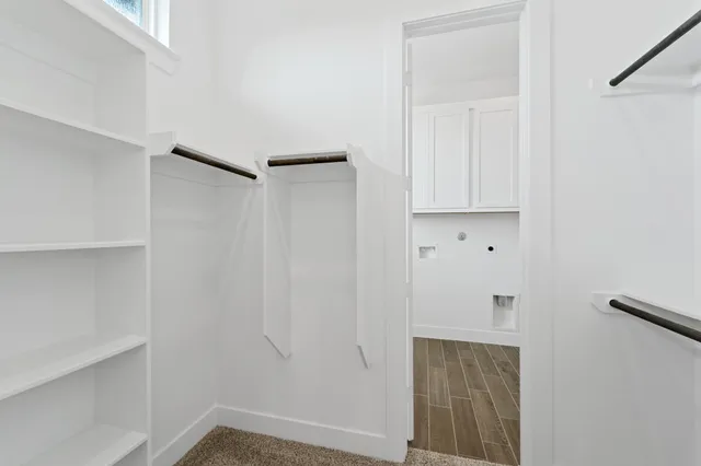 a view of walk in closet with empty racks