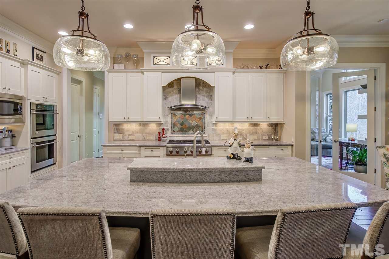 6037 Valencia Court Raleigh, NC 27614 - Photo 13 of 30 a kitchen with kitchen island granite countertop a stove and a chandelier