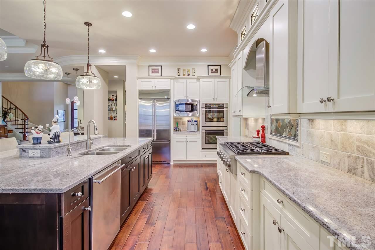 6037 Valencia Court Raleigh, NC 27614 - Photo 14 of 30 a kitchen with stainless steel appliances granite countertop a stove and cabinets