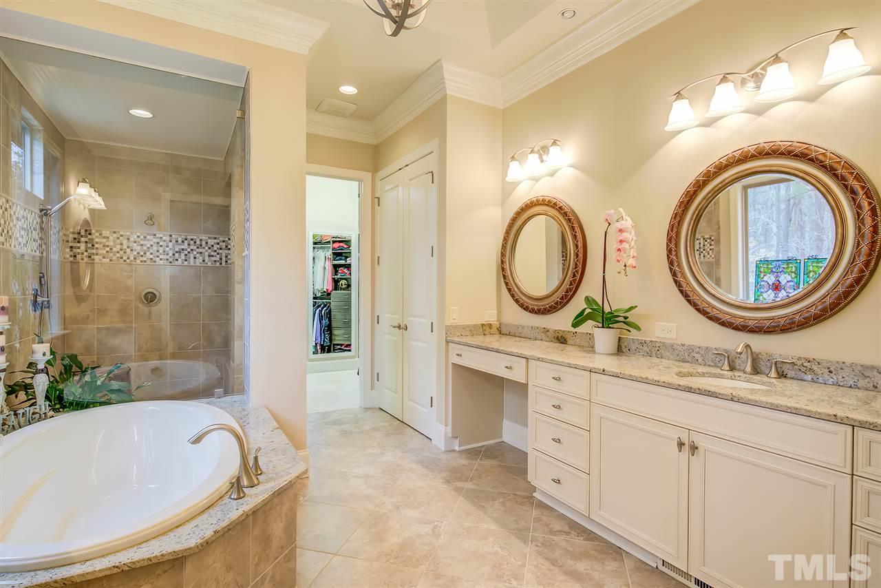 6037 Valencia Court Raleigh, NC 27614 - Photo 20 of 30 a bathroom with a granite countertop sink a mirror a bathtub and shower