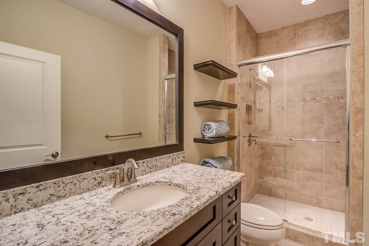 6037 Valencia Court Raleigh, NC 27614 - Photo 26 of 30 a bathroom with a granite countertop sink a mirror and a shower