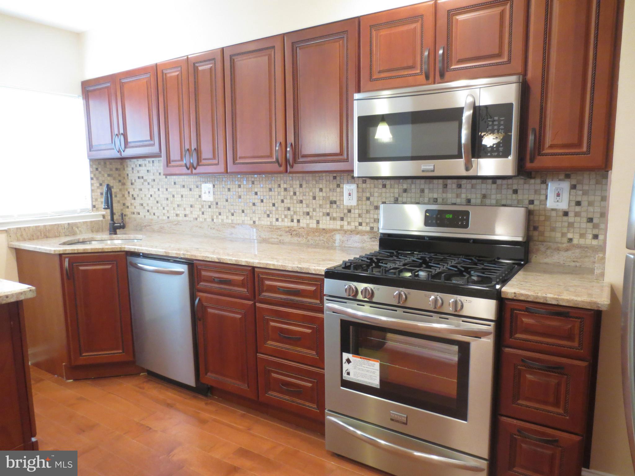1405 Kitmore Road Baltimore, MD 21239 - Photo 1 of 25 a kitchen with stainless steel appliances granite countertop a stove microwave and oven