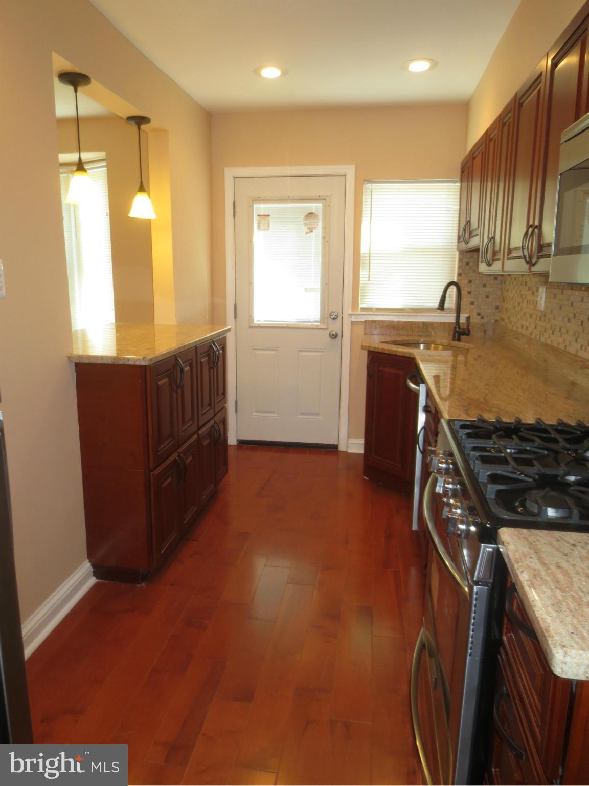 1405 Kitmore Road Baltimore, MD 21239 - Photo 4 of 25 a kitchen with stainless steel appliances granite countertop a stove a sink and a refrigerator