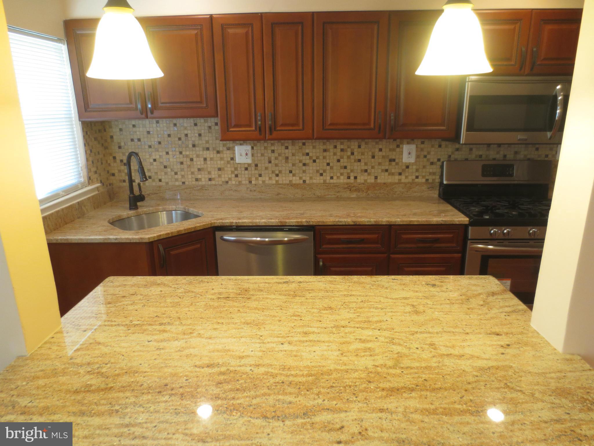 1405 Kitmore Road Baltimore, MD 21239 - Photo 7 of 25 a kitchen with granite countertop a sink a counter top space and cabinets