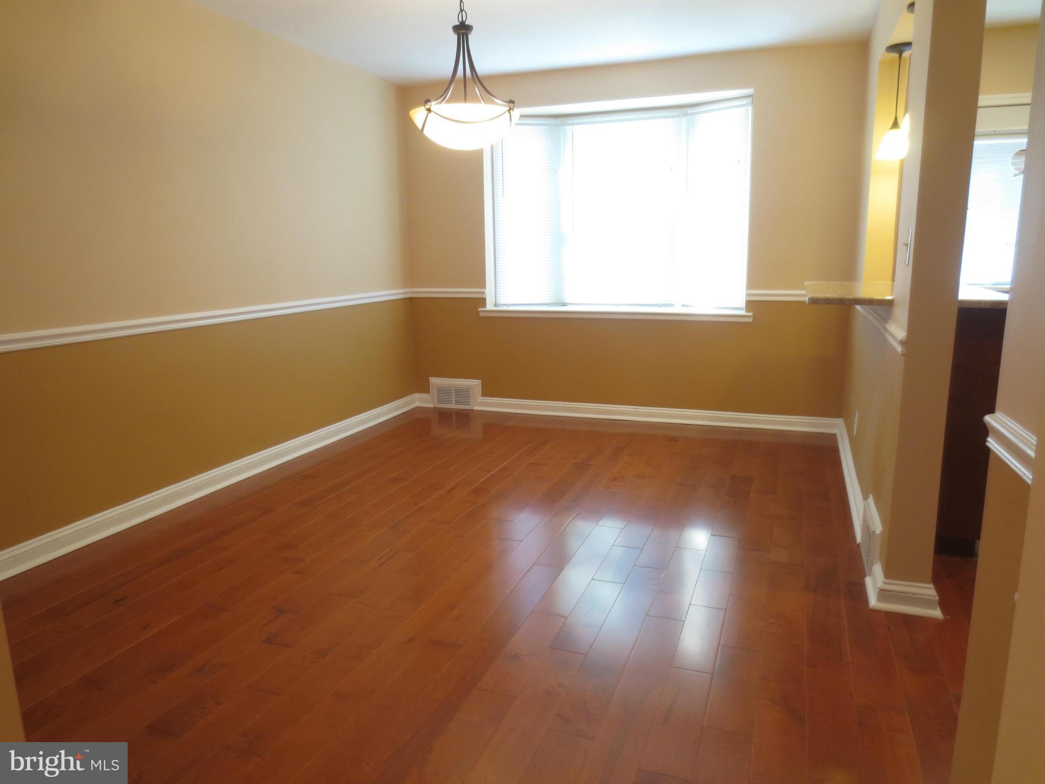 1405 Kitmore Road Baltimore, MD 21239 - Photo 8 of 25 an empty room with wooden floor and windows