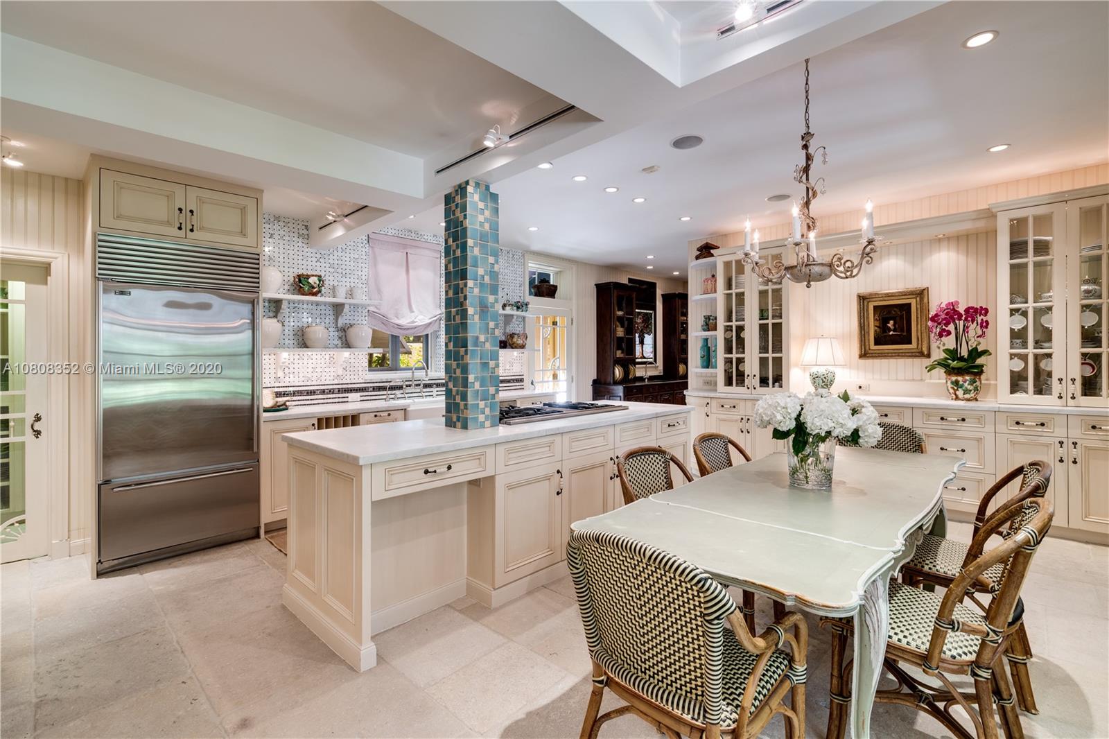 1030 Hardee Road Coral Gables, FL 33146 - Photo 15 of 55 a kitchen with kitchen island a dining table chairs sink and white cabinets