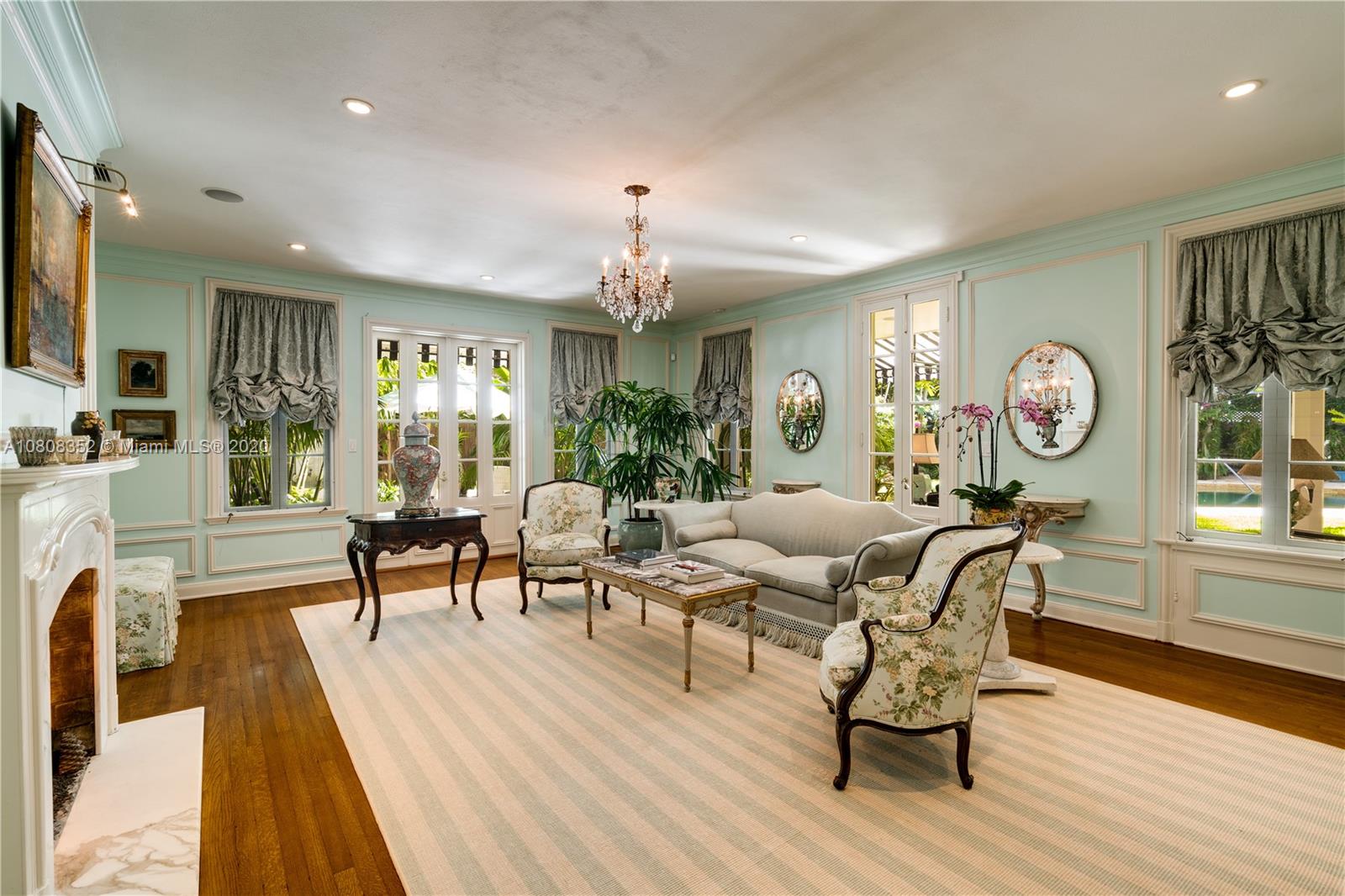 1030 Hardee Road Coral Gables, FL 33146 - Photo 5 of 55 a living room with furniture a chandelier couches and a dining table with wooden floor
