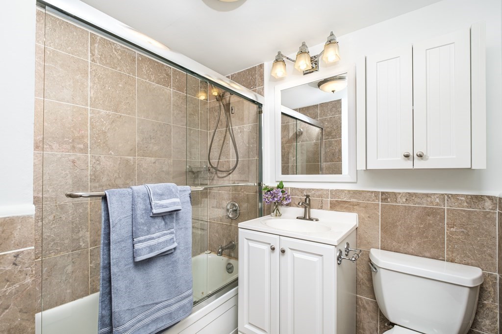 19 Winchester Street, Unit 801 Brookline, MA 02446 - Photo 11 of 19 a bathroom with a sink a toilet and a mirror