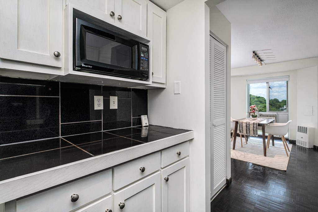 19 Winchester Street, Unit 801 Brookline, MA 02446 - Photo 6 of 19 a kitchen with granite countertop a stove a microwave and dining table