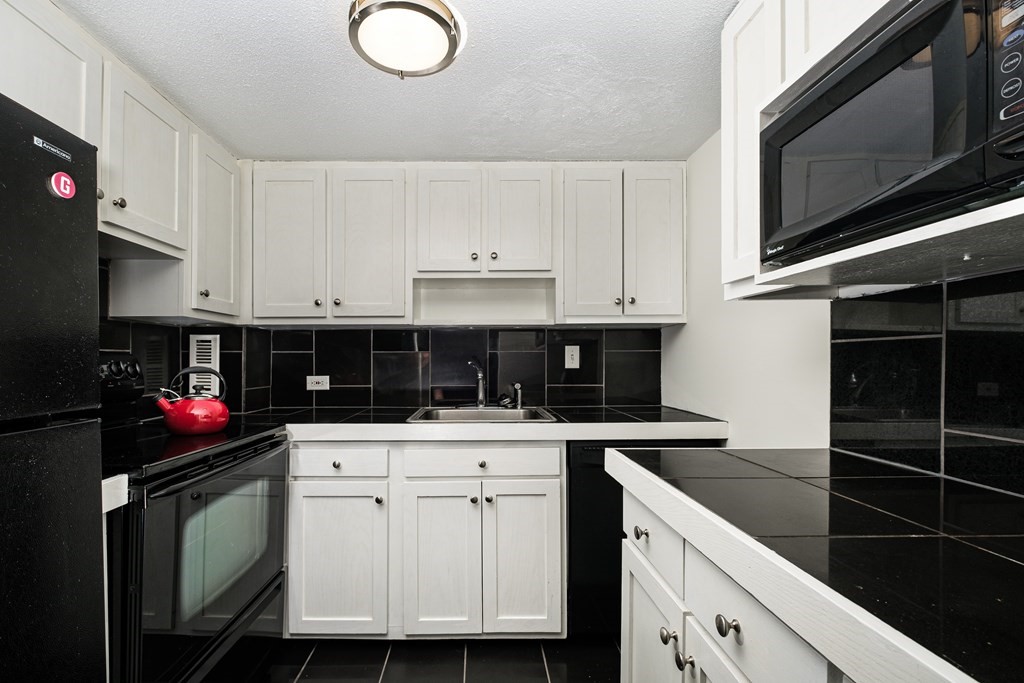 19 Winchester Street, Unit 801 Brookline, MA 02446 - Photo 7 of 19 a kitchen with granite countertop a sink dishwasher stove and cabinets