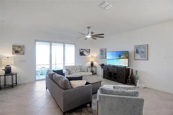 a living room with furniture ceiling fan and a window