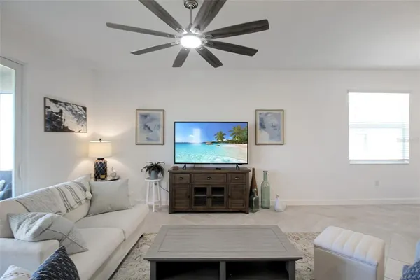 a living room with furniture a ceiling fan and a window