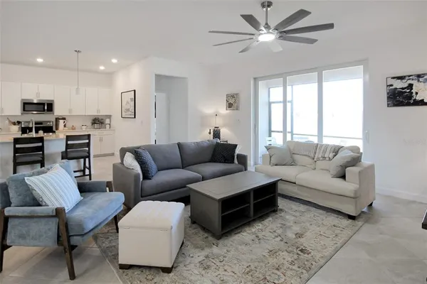 a living room with furniture a ceiling fan and a rug