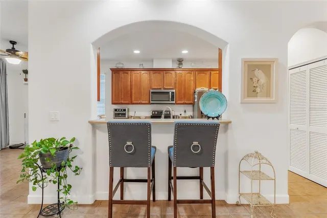 a view of kitchen with stainless steel appliances granite countertop a stove a sink a refrigerator and a dining table