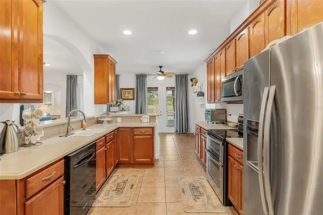 a large kitchen with stainless steel appliances granite countertop a sink stove and refrigerator