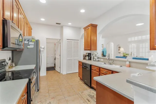 a large kitchen with stainless steel appliances a stove a sink a refrigerator and a counter space