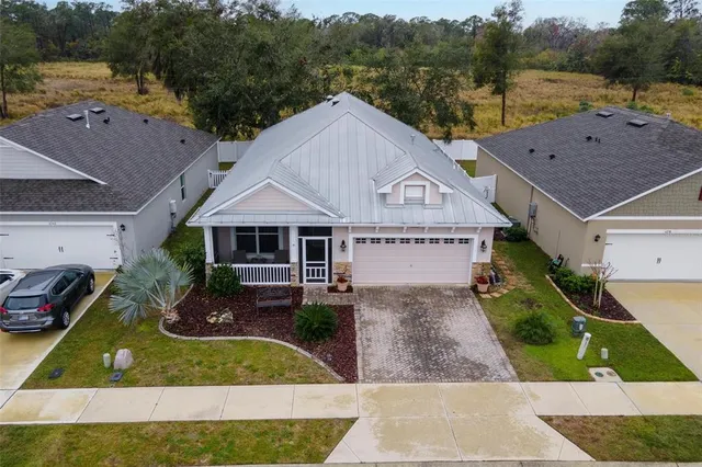 a aerial view of a house with a yard and large tree