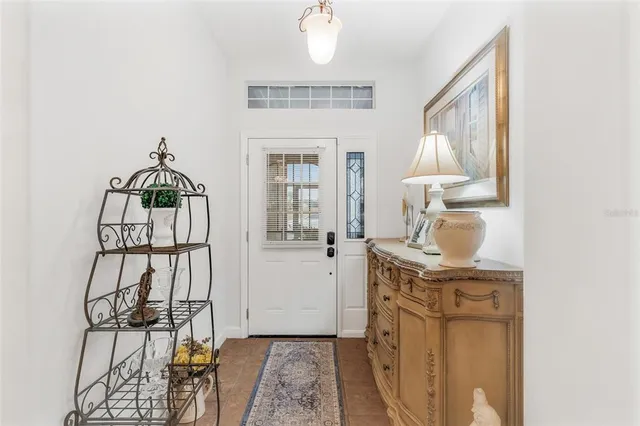 a hallway with a white cabinets and chandelier