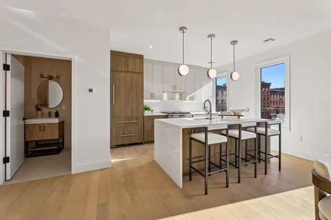 a kitchen with kitchen island a dining table chairs sink and cabinets