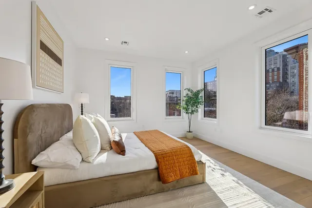 a bedroom with a bed and wooden floor
