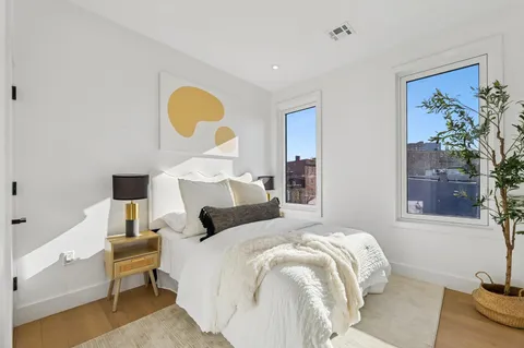 a bedroom with a bed and a painting on the wall