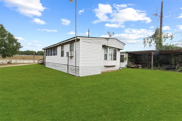 a view of a chair and table in backyard of the house