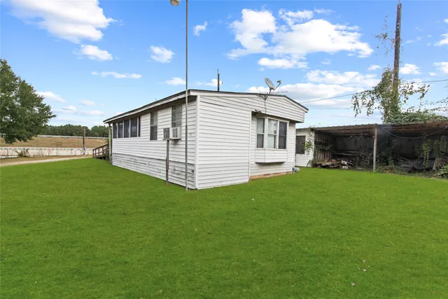 a view of a chair and table in backyard of the house