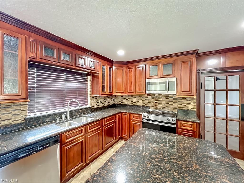 4210 South Hiawassee Road Orlando, FL 32835 - Photo 16 of 49 a kitchen with stainless steel appliances granite countertop a sink stove and cabinets