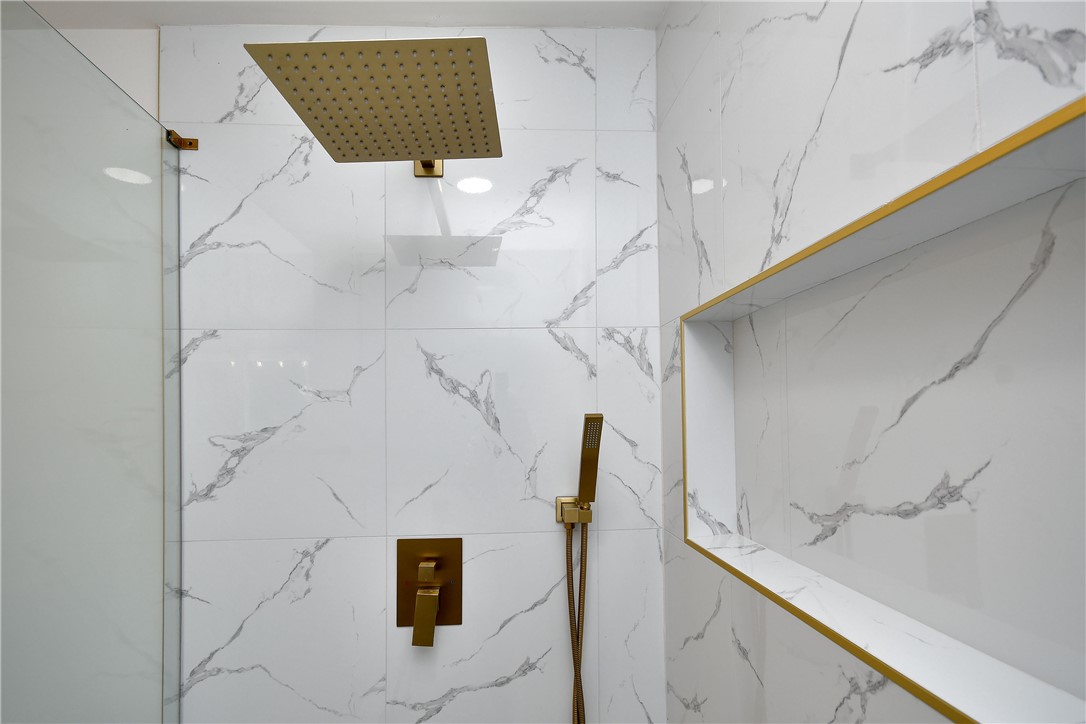 407 I Street Anderson, SC 29625 - Photo 33 of 43 Marble-patterned tile walls and golden fixtures define this well-appointed shower space.