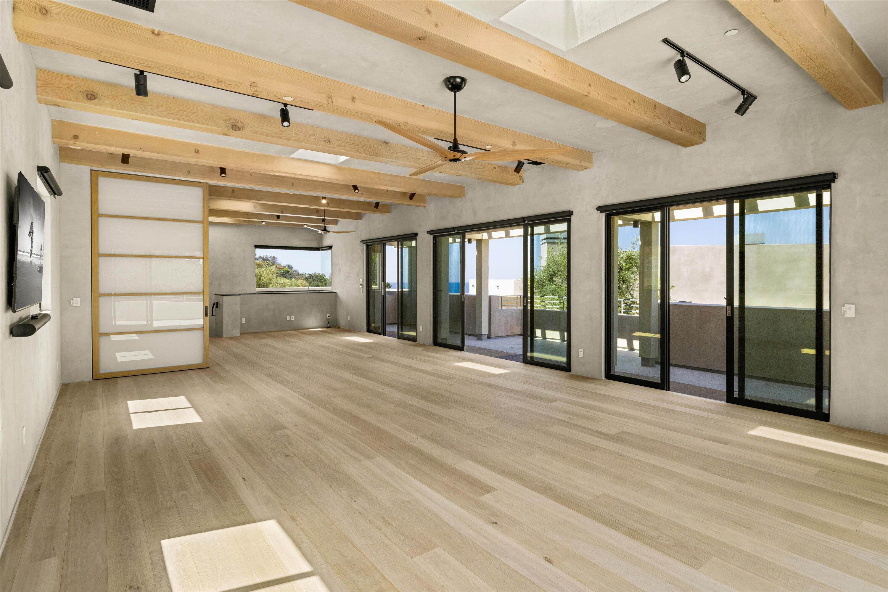 892 Toro Canyon Road Montecito, CA 93108 - Photo 21 of 40 a view of empty room with wooden floor and fan