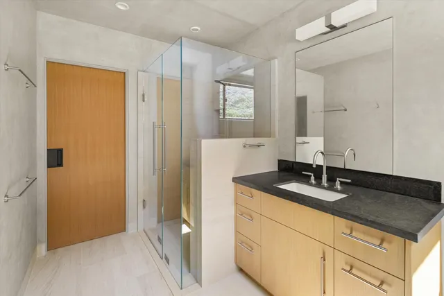 a bathroom with a granite countertop sink and a mirror