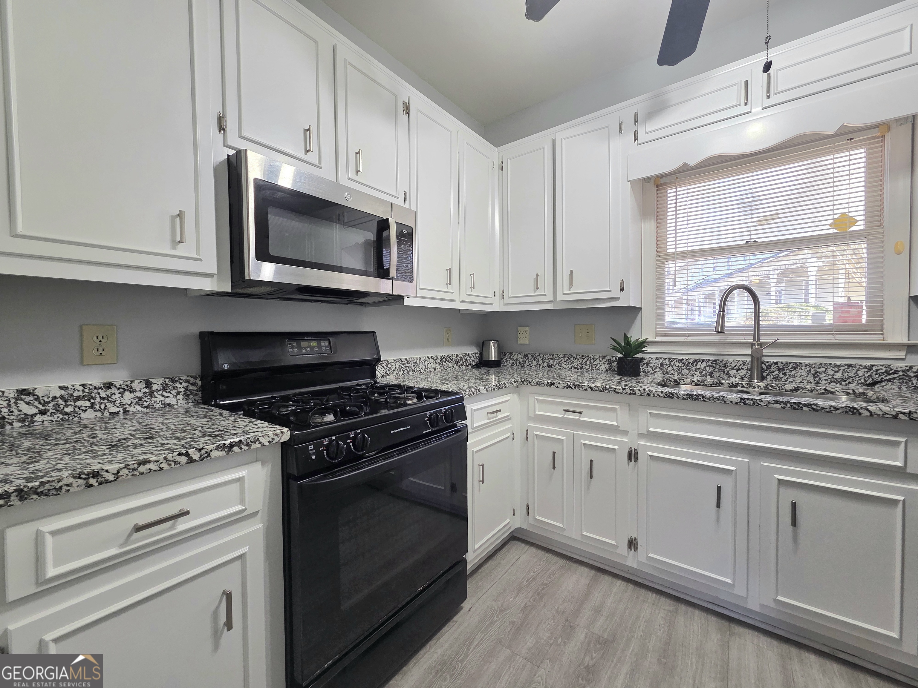 1426 Cambridge Common Decatur, GA 30033 - Photo 16 of 51 a kitchen with stainless steel appliances granite countertop white cabinets granite counter tops and a wooden floors