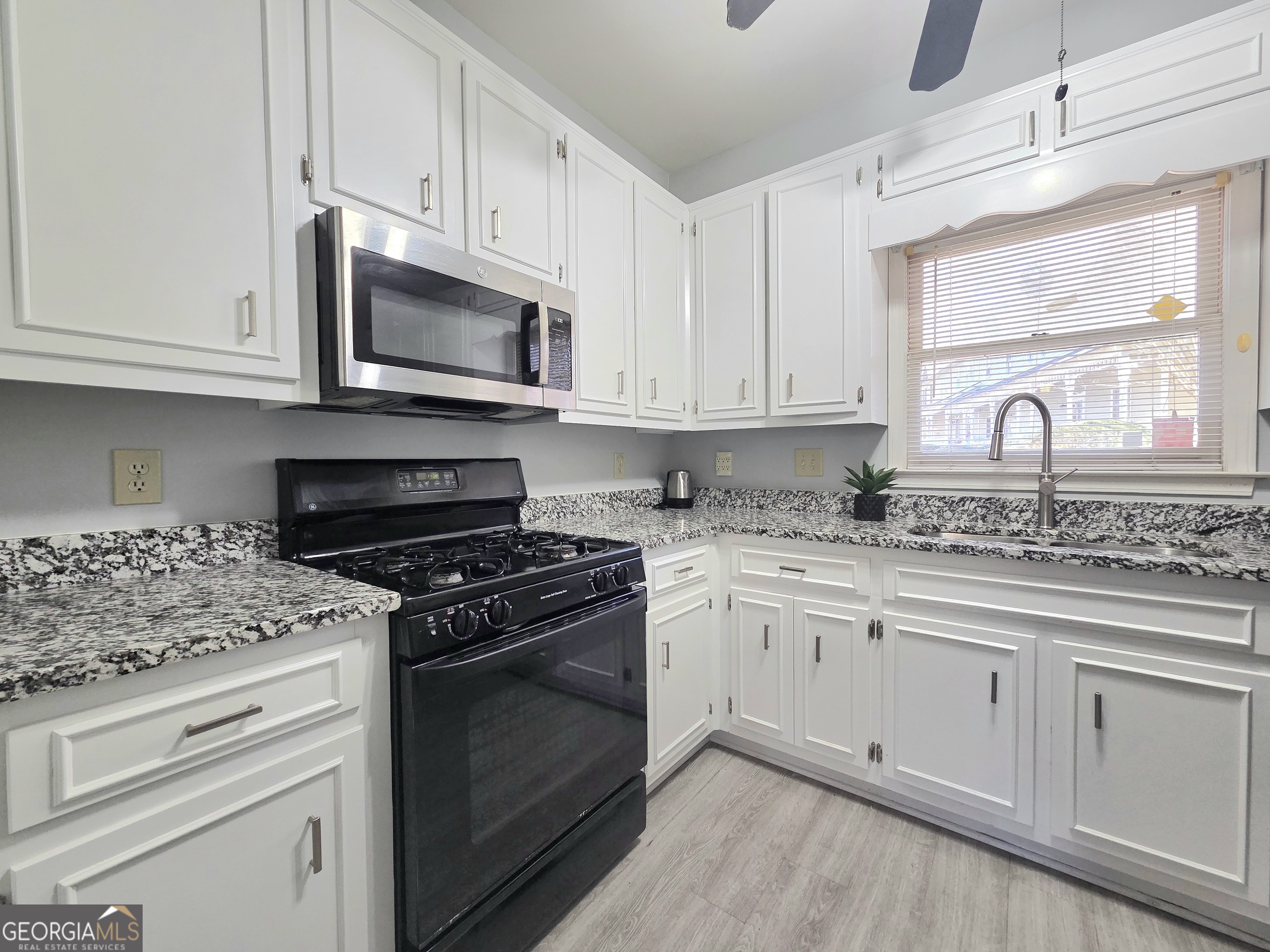 1426 Cambridge Common Decatur, GA 30033 - Photo 17 of 51 a kitchen with stainless steel appliances granite countertop white cabinets granite counter tops and a wooden floors