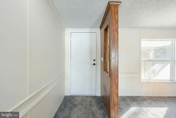 an empty room with windows and fireplace