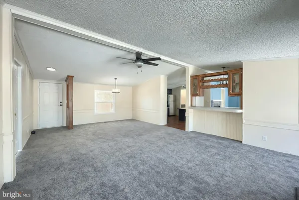 an empty room with windows cabinet and a rug