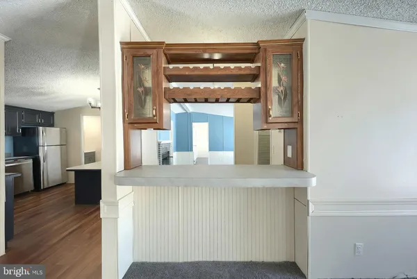 a large kitchen with stainless steel appliances granite countertop a refrigerator a stove top oven a sink dishwasher a dining table and chairs with wooden floor