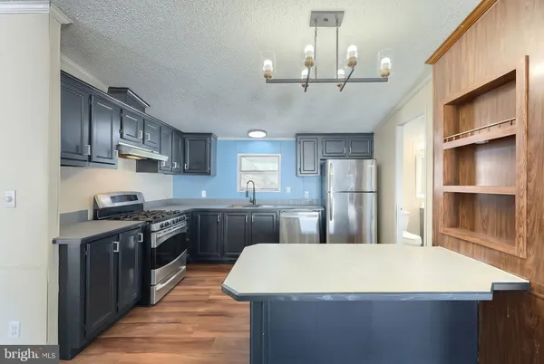 a kitchen with stainless steel appliances granite countertop a sink stove and cabinets