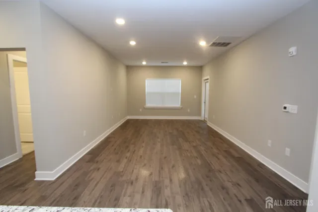 a kitchen with stainless steel appliances granite countertop a refrigerator a stove and a sink with wooden floor