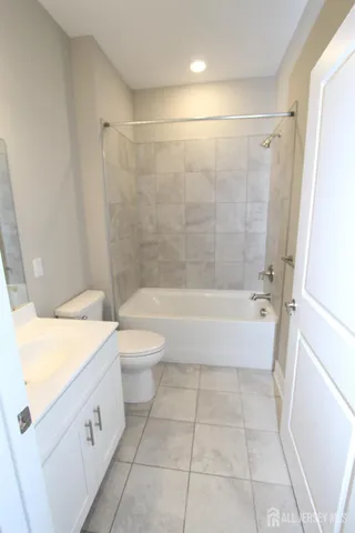 a spacious bathroom with a granite countertop toilet a sink and bathtub