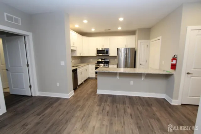 a view of kitchen with stainless steel appliances cabinets and wooden floor