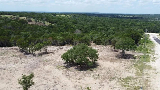 an aerial view of a houses with a yard and lake view